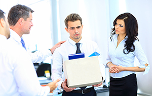 An employee worries about constructive dismissal as he carries his stuff while being consoled by his employer and two colleagues over the loss of his position.