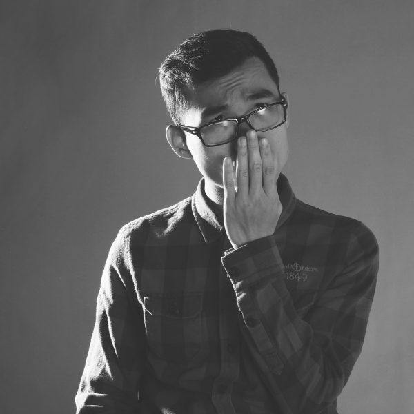 Sad man with hands on lips as he contemplates being a victim of workplace harassment